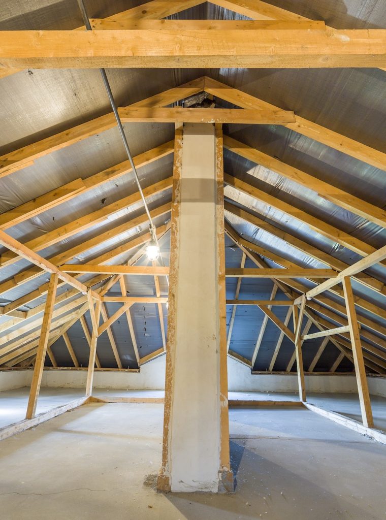 Attic of a building with wooden beams of a roof structure.